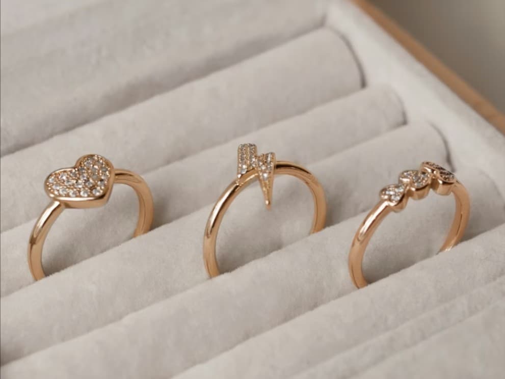 Gold fashion rings: heart, lightning bolt, and trio diamond band rings.