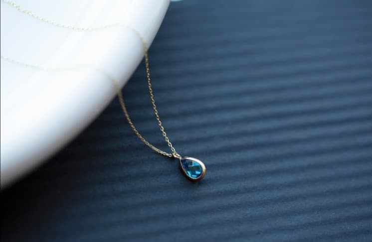 Gold necklace with blue teardrop pendant; jewelry repair, restoration