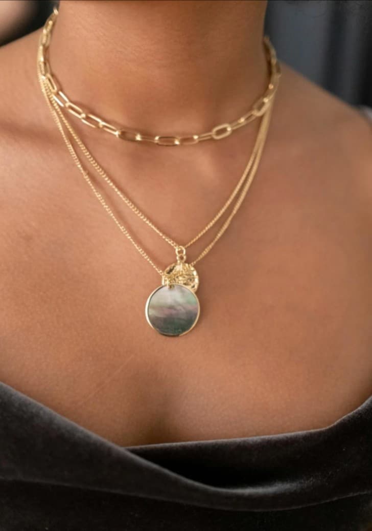 Gold layered necklaces: chain link, pendant with iridescent disc. Jewelry sales.