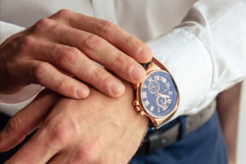 Man's hand wearing gold watch, potential watch repair or sales opportunity.