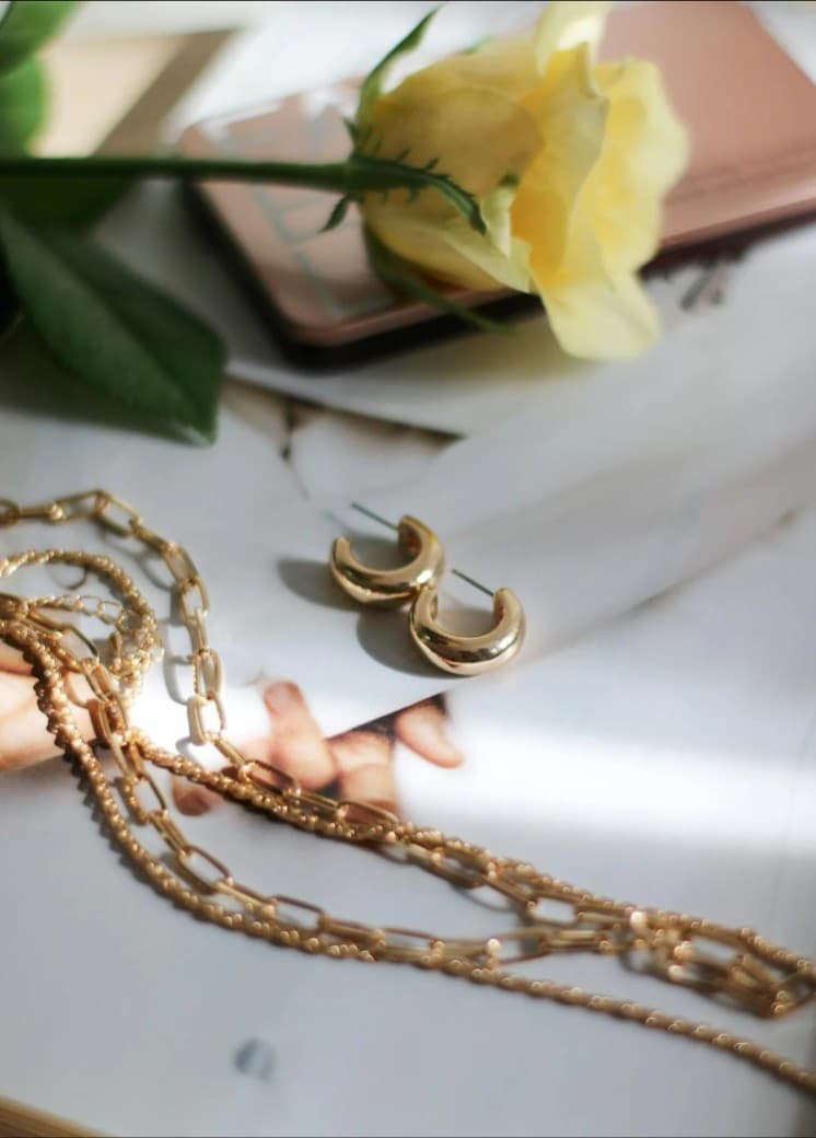 Gold hoop earrings and layered chain necklace. Jewelry sales and repair.